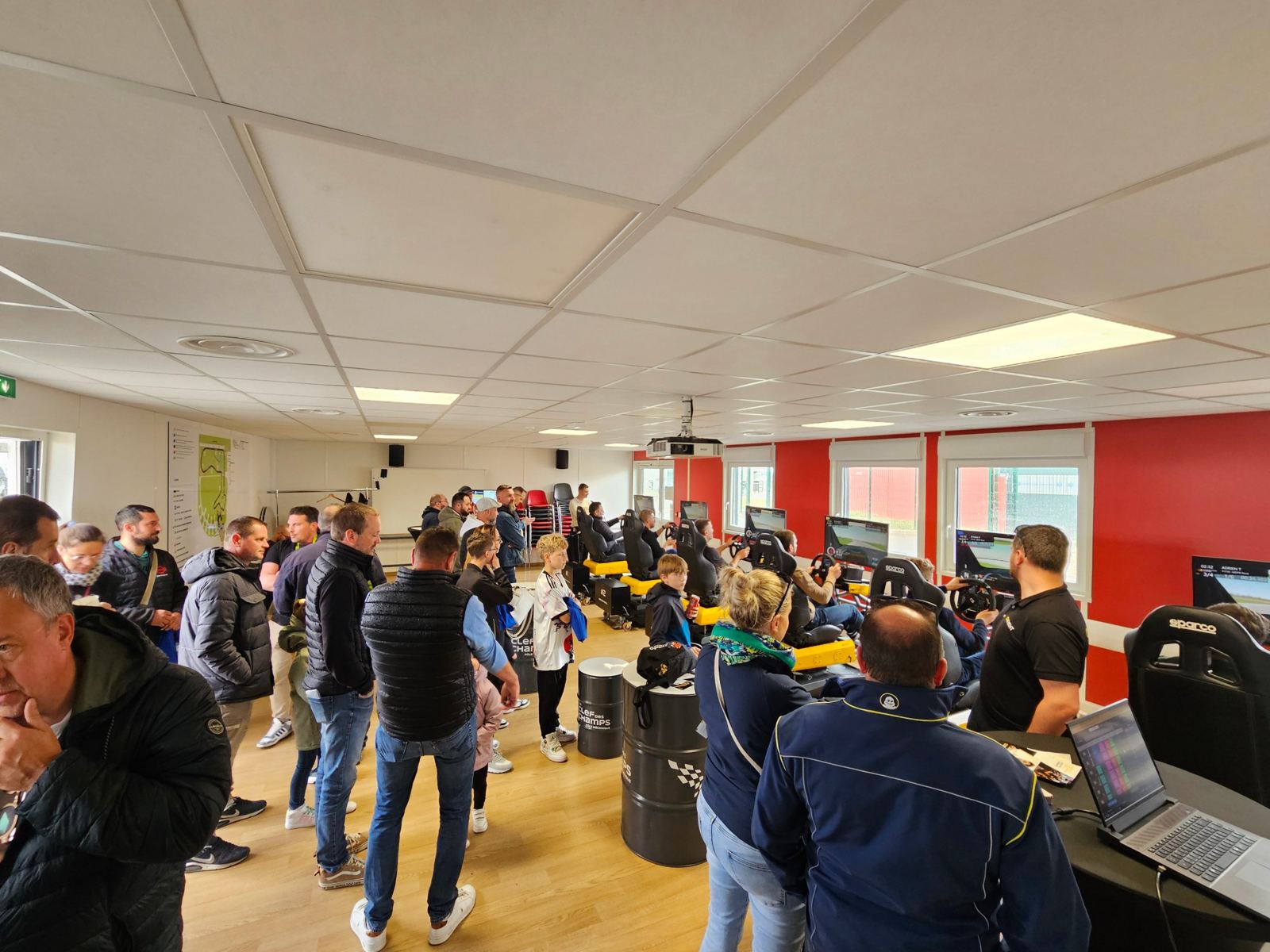 Participants et spectateurs autour des simulateurs dans une salle de réception